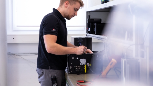 Mann, der Wartungsarbeiten an einem Ultraschallschweissgenerator durchführt