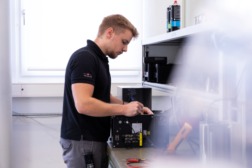 Mann, der Wartungsarbeiten an einem Ultraschallschweissgenerator durchführt